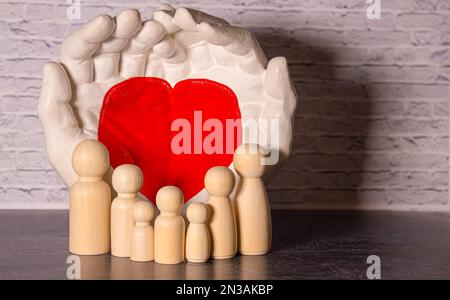 close up of womans cupped hands showing paper man family. Stock Photo