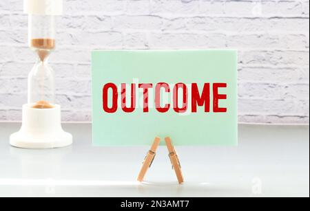 Black color letter in word outcome on white felt board background Stock Photo