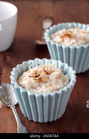 Rice pudding with sliced almonds in small blue bowls Stock Photo