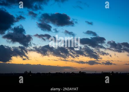 Rapidly drifting clouds contrast nicely with the evening twilight sky Stock Photo