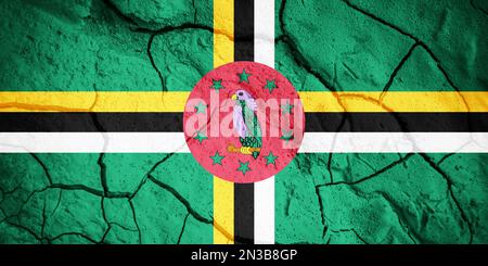 Flag of Dominica. Dominica symbol. Flag on the background of dry cracked earth. Dominica flag with drought concept Stock Photo