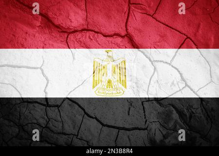 Flag of Egypt. Symbol of Egypt. Flag on the background of dry cracked earth. Egyptian flag with drought concept Stock Photo