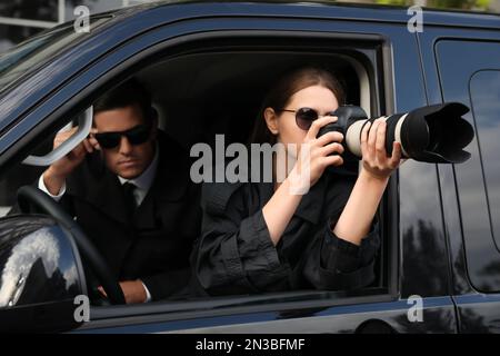 Private detectives with modern camera spying from car Stock Photo - Alamy