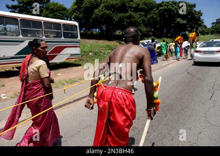 Durban, South Africa. 04th Feb, 2023. A woman looks on as a Hindu devotee from Chatsworth Magazine Barracks Shree Vishnu temple pulls a 2 metre long chariot during the annual Thaipoosam Kavady festival at Chatsworth, south of Durban, South Africa on February 4, 2023. The practice is part of a purification ritual in honor of a Hindu god, Muruga. (Photo by Mabhuti Msweli/Sipa USA) Credit: Sipa USA/Alamy Live News Stock Photo