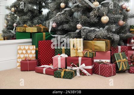 Many different gifts under Christmas tree indoors Stock Photo