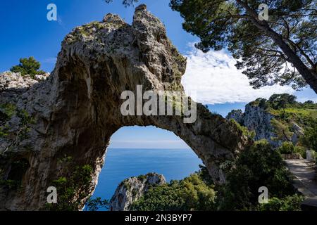 View through the Arco Naturale, a Palaeolithic era limestone arch, remains of a collapsed grotto, 18m high, span of 12m, on the east coast of the I... Stock Photo