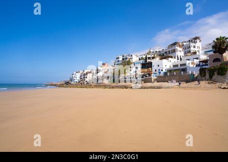 Apartments and restaurants on the hillside along Taghazout Village beach; Taghazout Bay, Agadir, Morocco Stock Photo