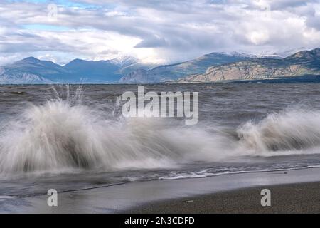 The rough waters of Kluane Lake crash on the shoreline. Klaune Lake is the largest lake in the Yukon; Yukon, Canada Stock Photo