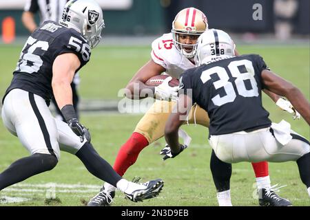 Oakland Raiders defensive end Justin Tuck (91), middle linebacker Miles  Burris (56) and safety Charles Woodson (24) surround Kansas City Chiefs  tight end Travis Kelce (87) as he picks up a first