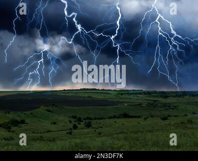 Dark cloudy sky with lightnings. Picturesque thunderstorm over field Stock Photo