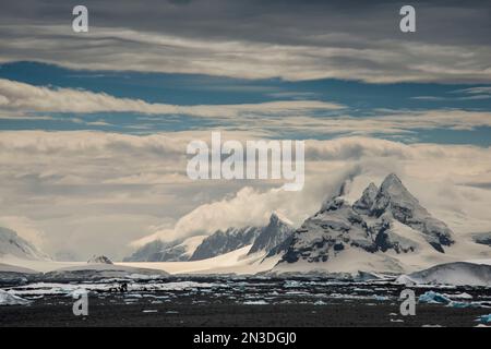 Mountainous, snow covered landscape on Booth Island along the icy ocean coastline, home to colonies of Gentoo, Adelie and Chinstrap Penguins Stock Photo