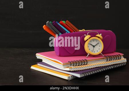 Different school stationery on stone table near blackboard. Back to school Stock Photo