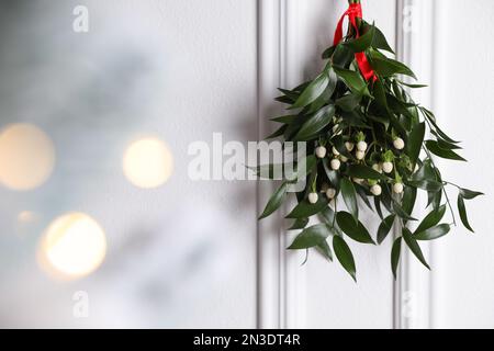 Mistletoe bunch tied with a red ribbon on white background. Traditional ...