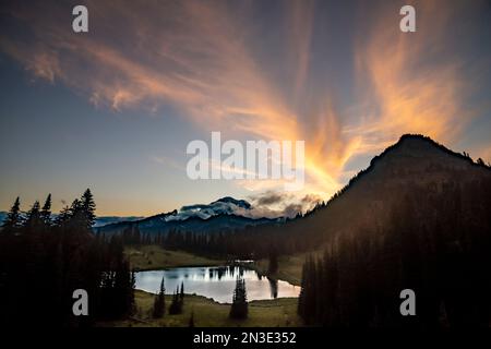 Sunset colors on Feather Clouds over Mount Rainier as seen from Tipsoo Lake in Mount Rainier National Park Stock Photo