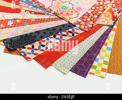 A display of rich and vibrant Japanese traditional patterns including the Seigaiha waves, Shippo Tsunagi circles or Asanoha leaves on a stack of furos Stock Photo