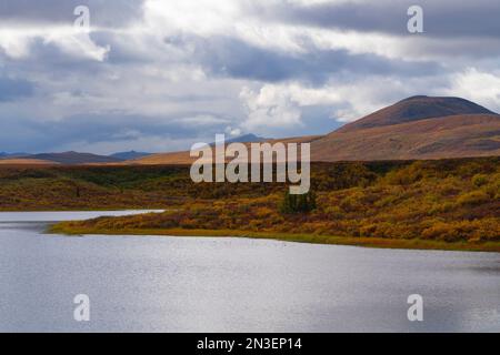 Two Moose Lake in autumn with fall colors while storm clouds clear out; Dawson City, Yukon, Canada Stock Photo