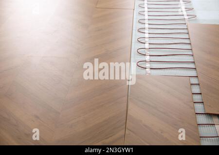 Installation of modern underfloor trace heating system indoors Stock Photo
