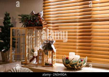 Beautiful Christmas lanterns on windowsill in decorated room Stock Photo