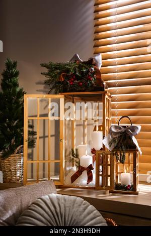 Beautiful Christmas lanterns on windowsill in decorated room Stock Photo