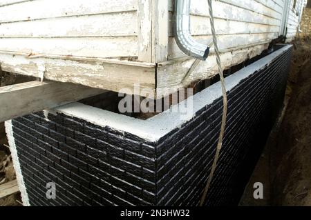 Black tar waterproofing on a newly-poured basement wall; Otoe, Nebraska, United States of America Stock Photo