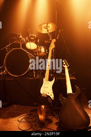 Tools of the rock trade. A drunkit and electric guitars standing on a stage before a concert. Stock Photo