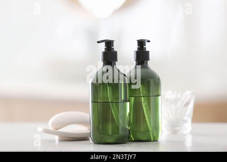 Green soap dispensers on white countertop in bathroom Stock Photo