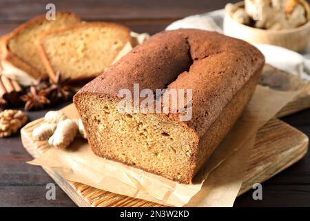 Delicious gingerbread cake and ingredients on wooden table, closeup Stock Photo