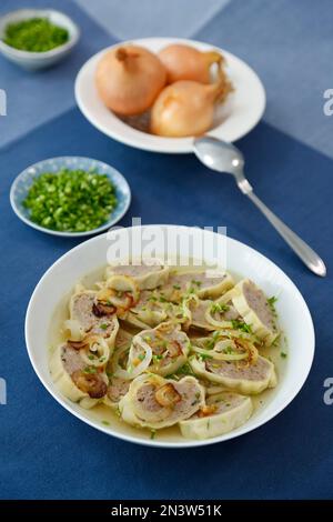 Swabian cuisine, Maultaschen in broth with stewed onions, soup plate, spoon, Germany Stock Photo