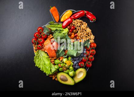 Healthy diet and nutrition for heart and cardiovascular system, healthy food, fruit and vegetables arrangement in realistic heart shape on black Stock Photo