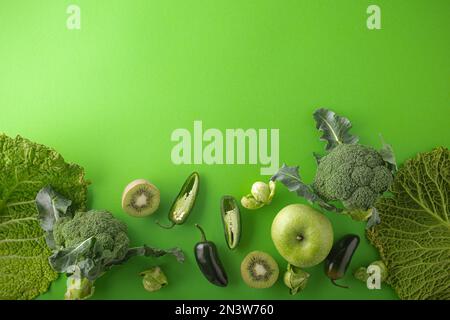 Creative layout food concept made of green fruit and vegetables on green background flat lay: avocado, kale, broccoli, Brussels sprouts, kiwi Stock Photo
