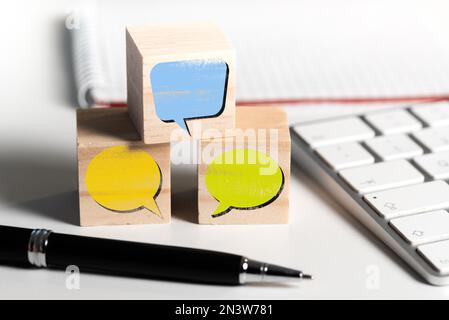 empty speech bubbles on wooden blocks on office desk, communication concept Stock Photo
