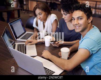 We make studying look easy. A group of students using a laptop to complete a group assignment. Stock Photo