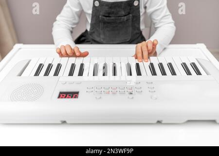 Children's hands on the keys of the synthesizer. Stock Photo