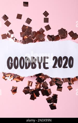 Flat lay composition with phrase Goodbye 2020 and confetti on pink background Stock Photo