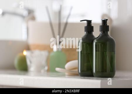 Green soap dispensers on countertop near sink in bathroom. Space for text Stock Photo