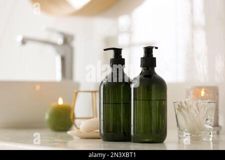 Green soap dispensers on countertop near sink in bathroom. Space for text Stock Photo