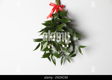 Fresh mistletoe hanging on a red ribbon on white background Stock Photo ...