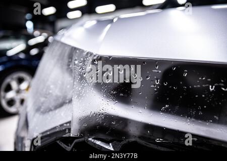 Protection of hood and front of the car with a colorless ppf protective film.  Stock Photo