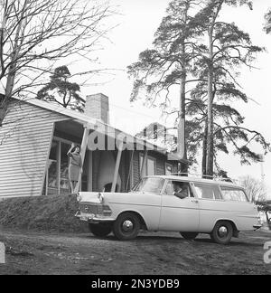 Couple in the 1960s. A woman is wavinig at her husband that sits in their car a Opel Olympia.  Sweden 1961 Kristoffersson Ref CT49-1 Stock Photo