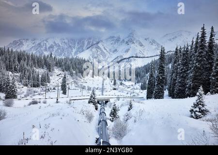 Landscape of the snow spruce and famous iron water pipe line from Big Almaty Mountain Lake with in Tien Shan, Kazakhstan. Stock Photo