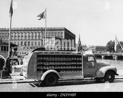 Coca cola in the 1950s. In 1 january 1953 Coca-Cola was first allowed to be manufactured and sold in Sweden, previously being restricted from sales in Sweden since the content of Coca-cola included forbidden substances like phosphoric acid and caffeine. One of the first  distribution trucks of the brewery Mineralvattenfabriken Tre Kronor loaded with Coca-Cola bottles pictured in Stockholm with the royal castle in the background. Volvo trucks model L34 modifyed and painted in red for the exclusive use on Coca-Cola trucks. Coca-Cola was early with having advertising on their vehicles. Sweden 195 Stock Photo