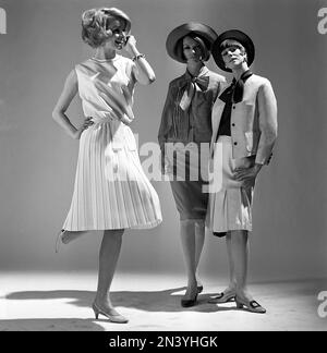 In the 1960s. Three fashion models in a studio wearing the fashion of the summer of 1965. A white Marilyn Monroe inspired dress stands out. Sweden 1965 Stock Photo