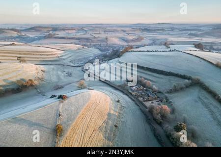 Uploders, Dorset, UK.  8th February 2023.  View from the air of the white frost covered fields at Uploders in Dorset on a clear frosty morning shortly after sunrise after a night of freezing temperatures.  Picture Credit: Graham Hunt/Alamy Live News Stock Photo