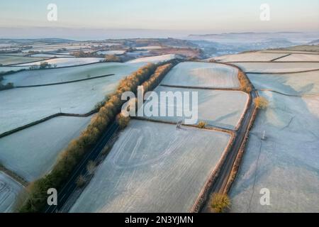 Uploders, Dorset, UK.  8th February 2023.  View from the air of the white frost covered fields at Uploders in Dorset on a clear frosty morning shortly after sunrise after a night of freezing temperatures.  Picture Credit: Graham Hunt/Alamy Live News Stock Photo