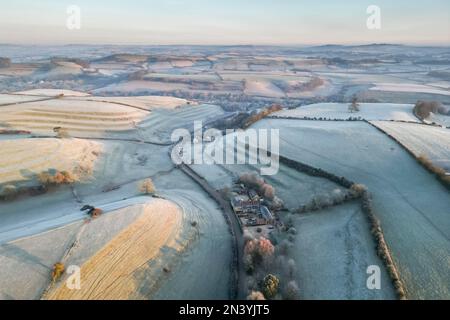 Uploders, Dorset, UK.  8th February 2023.  View from the air of the white frost covered fields at Uploders in Dorset on a clear frosty morning shortly after sunrise after a night of freezing temperatures.  Picture Credit: Graham Hunt/Alamy Live News Stock Photo