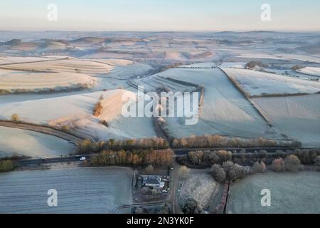 Uploders, Dorset, UK.  8th February 2023.  View from the air of the white frost covered fields at Uploders in Dorset on a clear frosty morning shortly after sunrise after a night of freezing temperatures.  Picture Credit: Graham Hunt/Alamy Live News Stock Photo