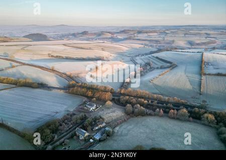 Uploders, Dorset, UK.  8th February 2023.  View from the air of the white frost covered fields at Uploders in Dorset on a clear frosty morning shortly after sunrise after a night of freezing temperatures.  Picture Credit: Graham Hunt/Alamy Live News Stock Photo