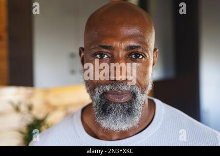 Close-up portrait of bald and bearded african american senior man in log cabin Stock Photo