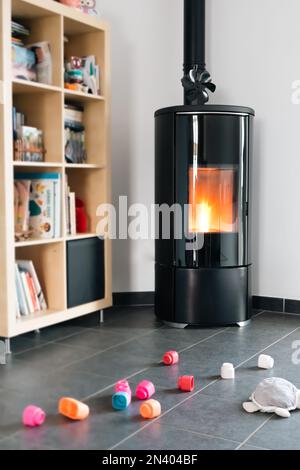 Pellet stove with some toys in front, with flames and library Stock Photo