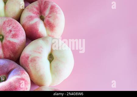 flat peaches isolated on pink background. figs peaches. fresh delicious peaches. copy space Stock Photo